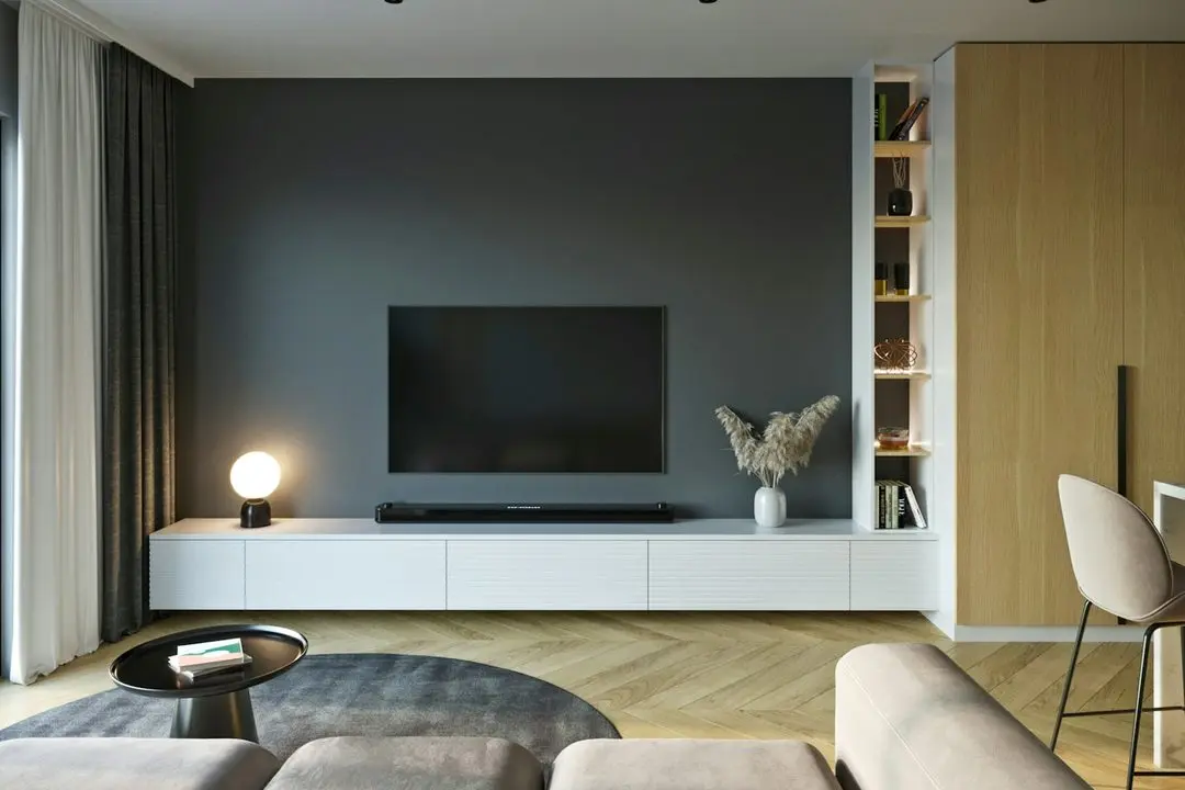 Living room with a TV on a dark grey wall above a low white media unit